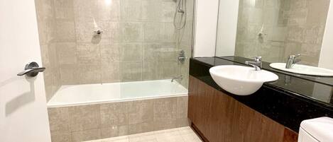 A modern bathroom with a glass-enclosed shower, a bathtub, a sink, and a toilet.