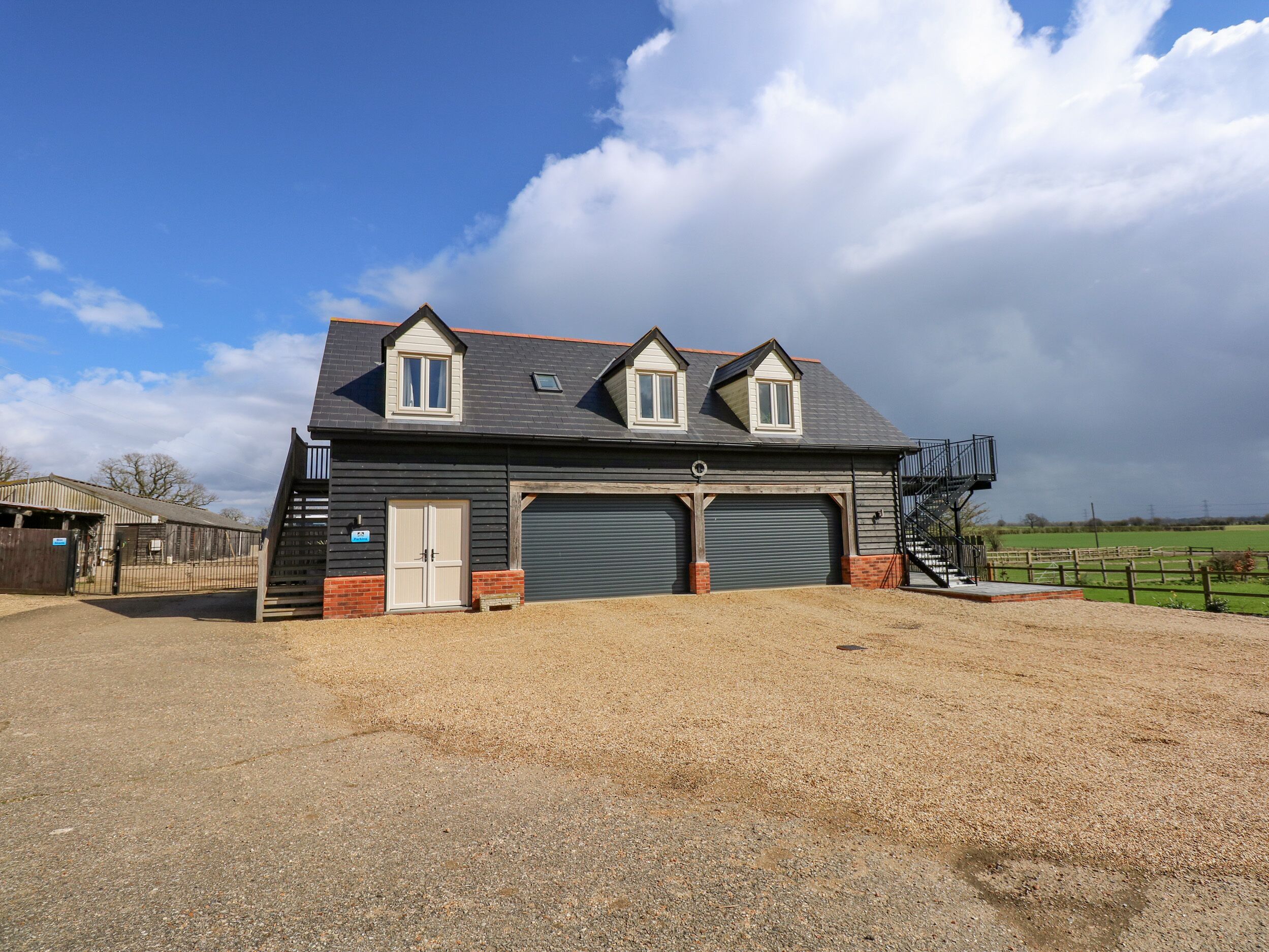 A two-story building with a garage and a covered driveway.