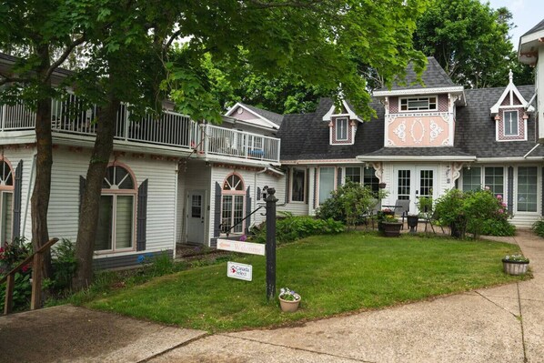 A row of traditional-style houses with a 'Welcome' sign, a 'Canada Select' sign, and a well-maintained lawn.