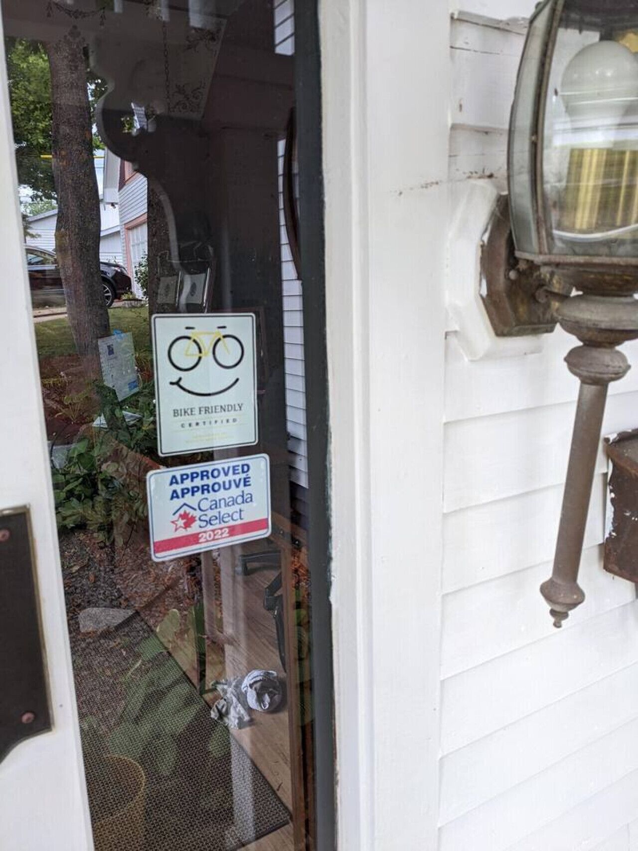 A door with a 'Bike Friendly' sign and an 'Approved Canada Select' sign.