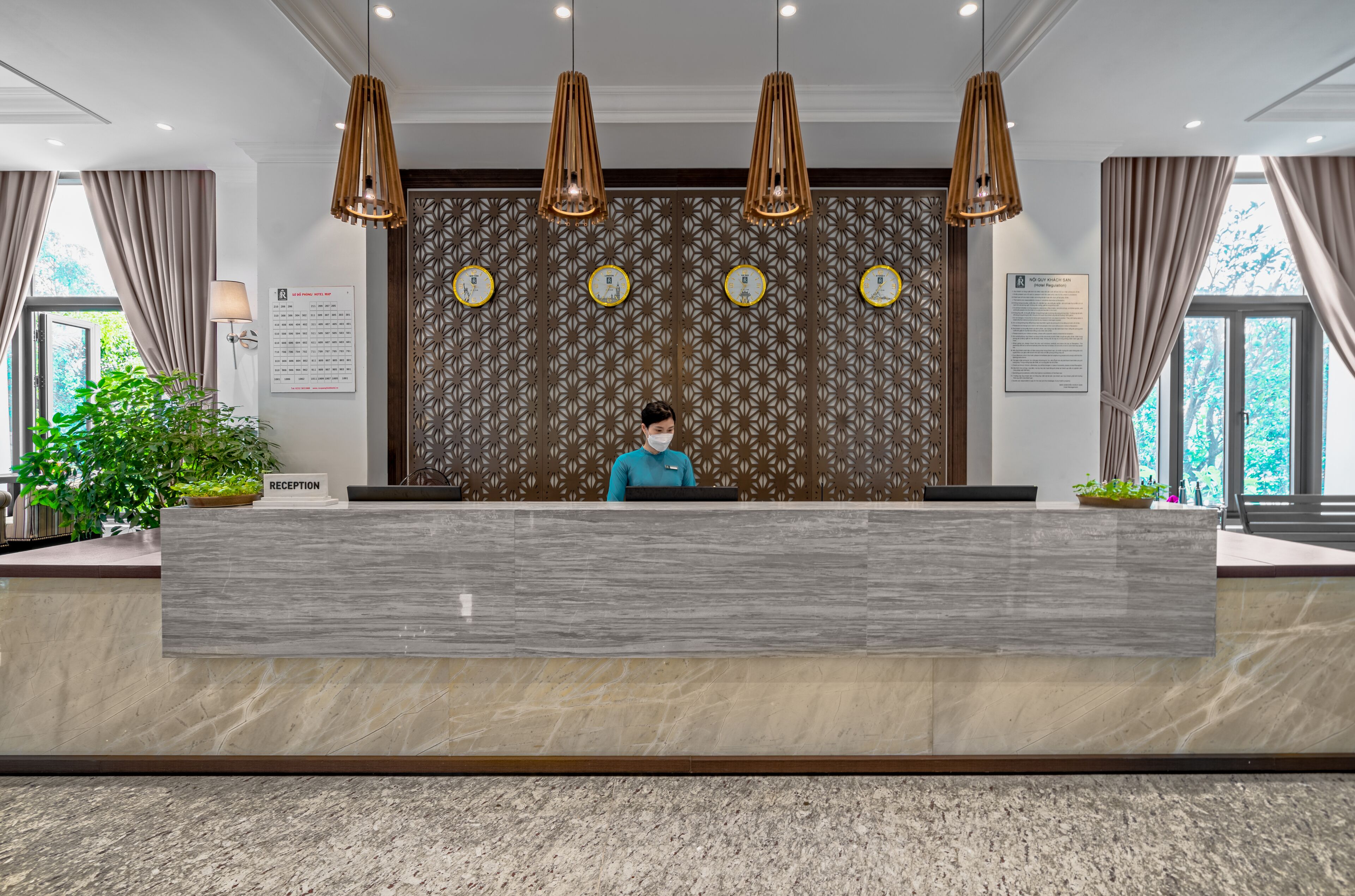 Un mostrador de recepción de diseño moderno, una recepcionista y una pared con estampado.