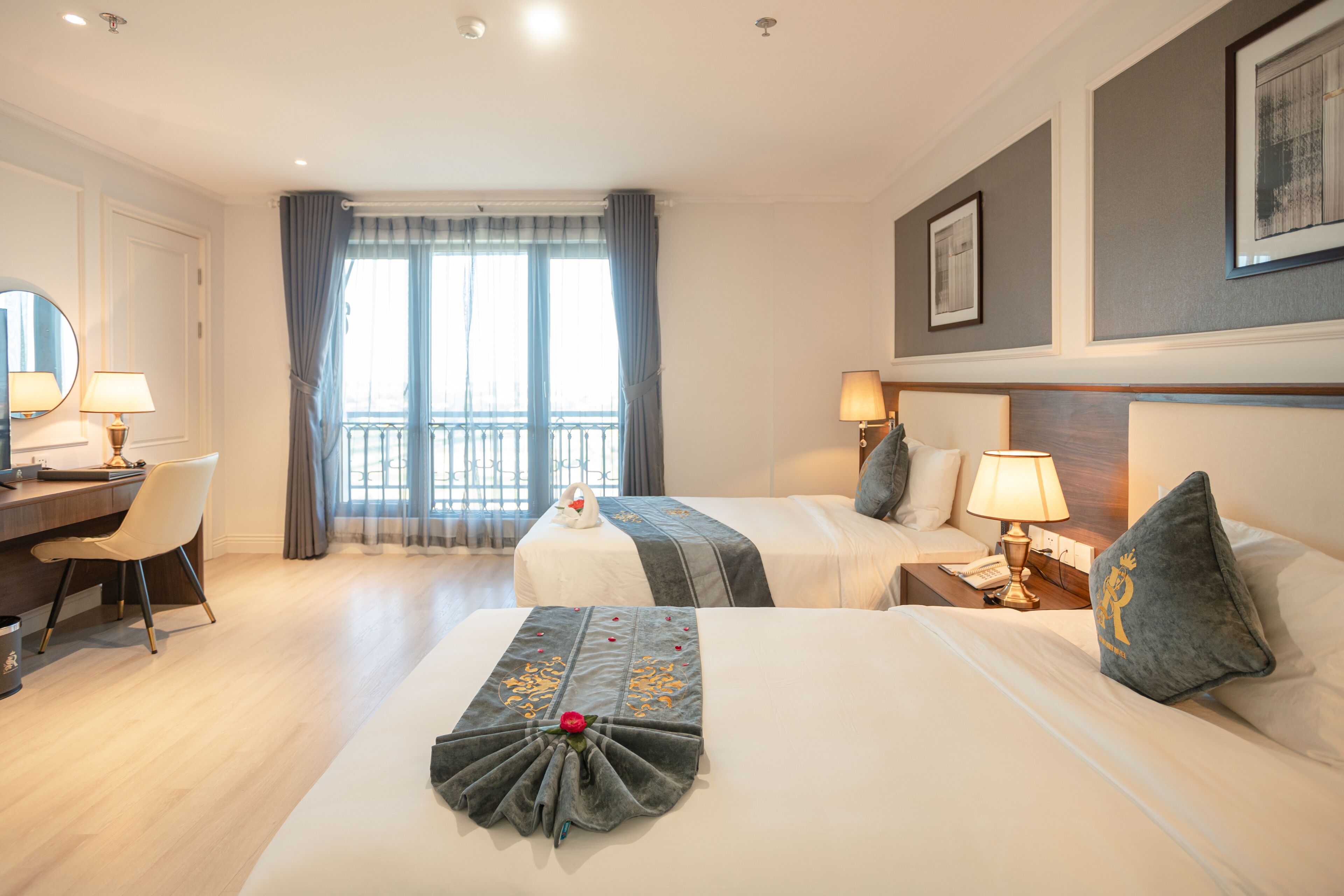 Una camera d'albergo con due letti, una scrivania e una sedia.