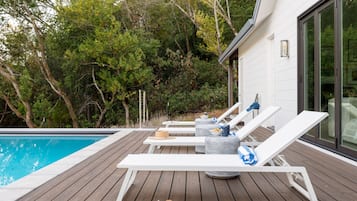 Een infinity pool, ligstoelen bij het zwembad