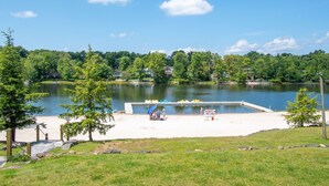 A lakeside swimming area with a dock, a sandy beach, and a small pier. - 6 Bedroom sleeps 17 in the Heart of Poconos near everything  (Tobyhanna)