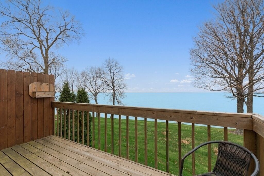 Une terrasse en bois offrant une vue sur un lac et des arbres.