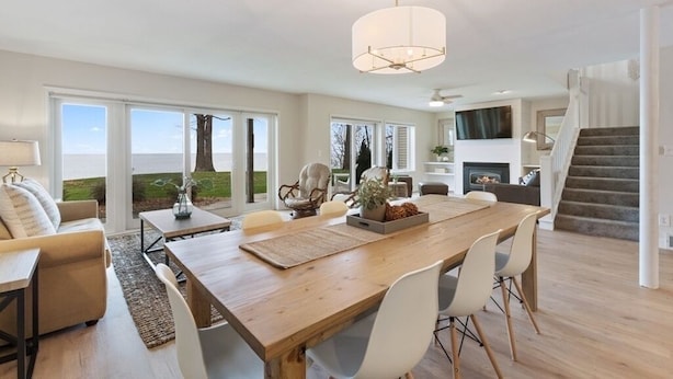 Un salon spacieux avec une grande table à manger en bois, des sièges confortables et une vue sur l’extérieur.