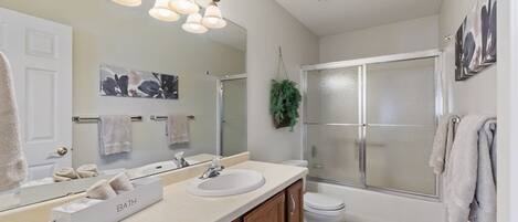 A modern bathroom with a vanity, sink, and mirror.