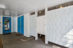 Ein Flur mit einer blauen Tür, weißen Wänden und einem Holzboden.