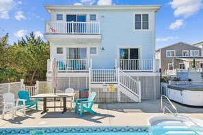 Un bâtiment à deux étages doté d’un balcon, d’une piscine et de mobilier d’extérieur.