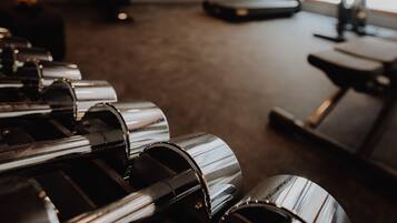 A gym with exercise equipment, a treadmill, and a mirror.