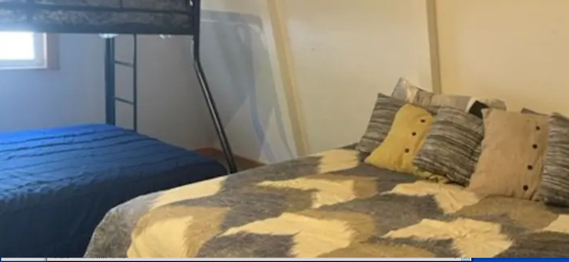 A bedroom with a bunk bed and a single bed, both with patterned bedding.