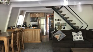 Un espace de vie moderne de style « loft », comprenant une cuisine, un coin repas et un escalier menant à un niveau supérieur.