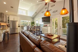 A spacious kitchen with a dining area, a large window, and a ceiling fan.