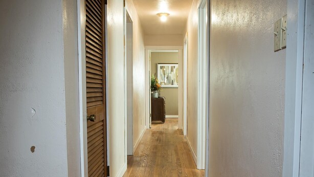A hallway with wooden flooring and white walls. - Triple H Properties (Eminence)