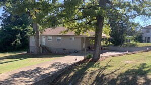 A residential house with a front yard, a driveway, and a sidewalk. - Triple H Properties (Eminence)