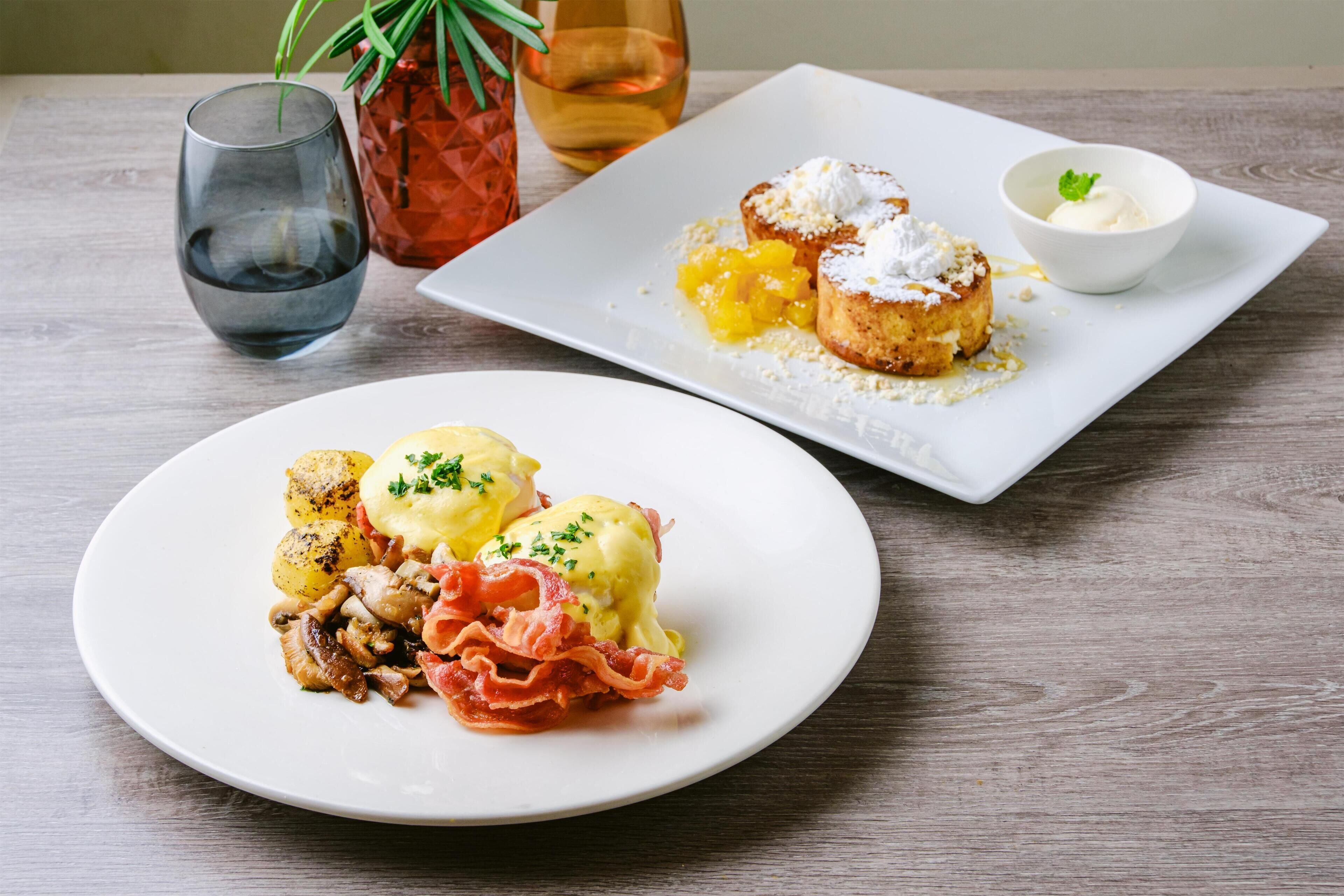 Two plates of food on a wooden table.