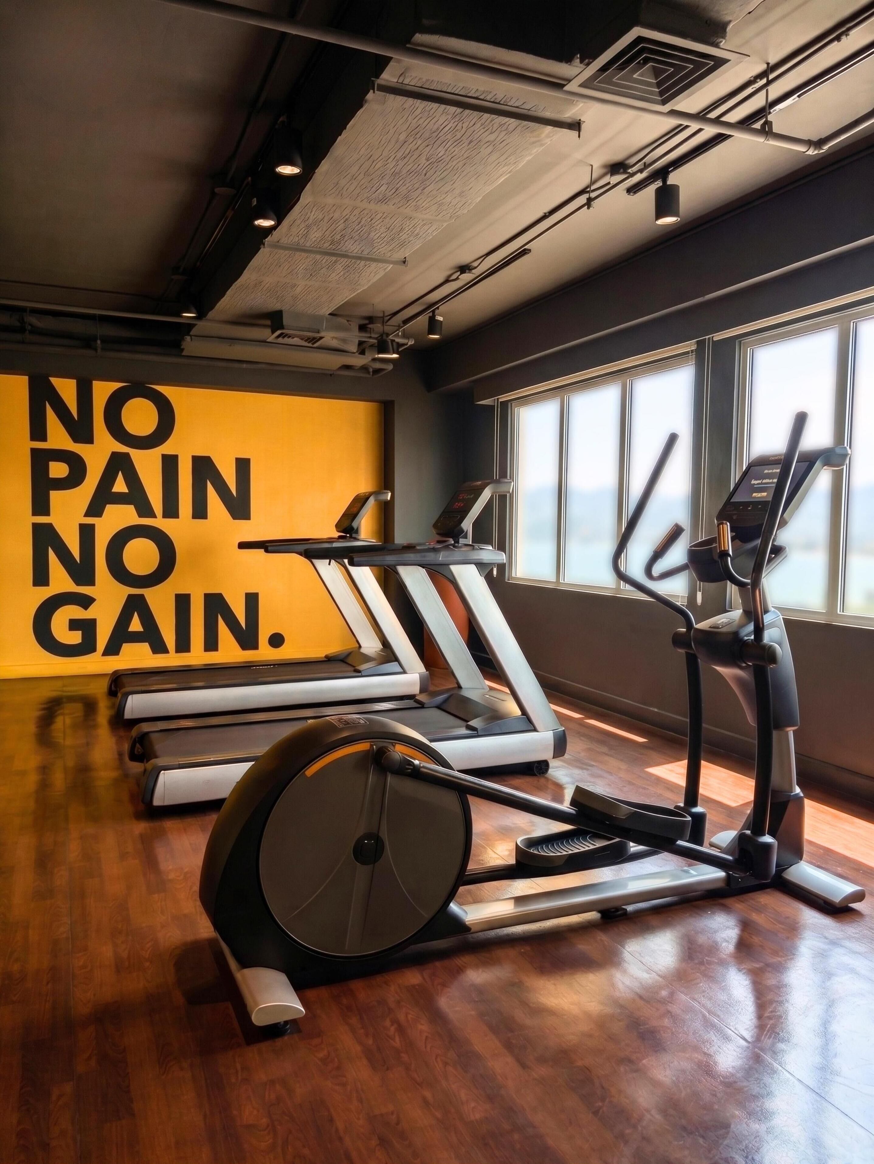 A gym with treadmills, an elliptical, and a stationary bike.