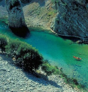 A clear turquoise river with rocky banks and a kayaker. - Obrovackrusevo, Modern apt w. Terrace & sea View (Obrovac)