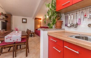 Compact kitchen with modern design, featuring a sink, cabinet, and potted plant.