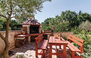 Enjoy al fresco dining on the patio with a brick oven, picnic table, and comfortable seating.