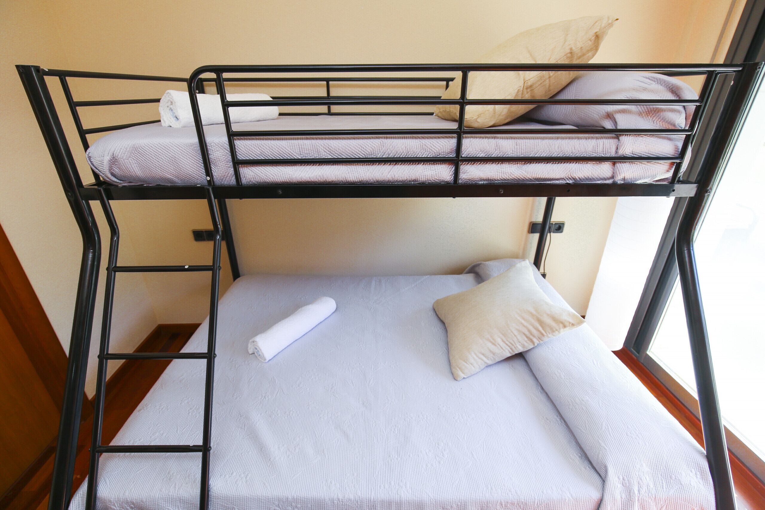 Una cama litera con un colchón blanco y una toalla enrollada en la cama inferior.