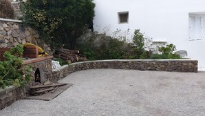 Un bâtiment blanc avec un mur en pierre et une allée gravillonnée.