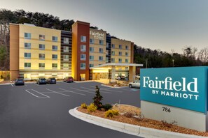 A Fairfield by Marriott hotel with a parking lot and a signboard.