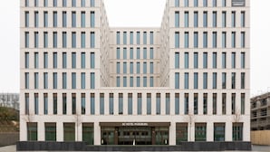 A modern hotel building with a symmetrical facade, multiple floors, and a central entrance. - AC Hotel by Marriott Wuerzburg (Würzburg)