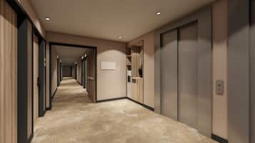 A hotel corridor with a long hallway, wooden paneling on the left, and a carpeted floor.