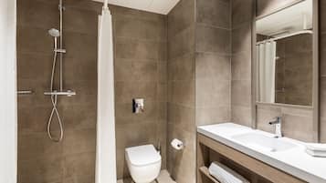 A modern bathroom with a shower, toilet, and sink.