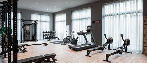 A modern gym with cardio equipment, weight machines, and free weights.