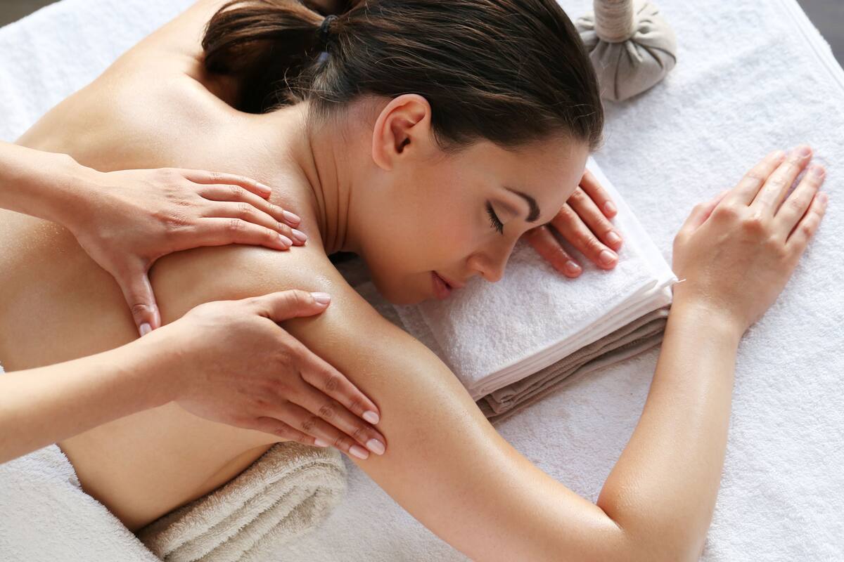 A person receiving a massage on a white towel.