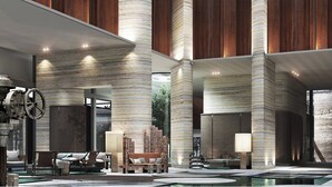 A spacious lobby with high ceilings, large pillars, and modern furniture.