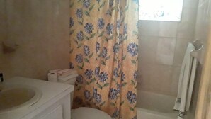 A bathroom with a toilet, a sink, and a bathtub.