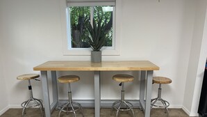 A kitchen with a wooden table and four stools.