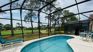 A swimming pool with a view of a golf course through a covered area. - Private Pool - TV in all Bedrooms - Newly renovated - Golf View (Haines City)