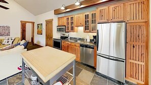 A modern kitchen with wooden cabinets, stainless steel appliances, and a central island. - Mountain Retreat | Fire Pit | 3 Blocks off Main St. (Grand Lake)