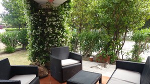 A patio with wicker furniture, a small table, and a cat. - Holidays at Hydrangea Villa (San Teodoro)