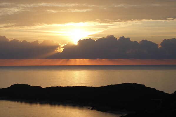 A coastal sunset with a calm sea and rocky shoreline. - Holidays at Hydrangea Villa (San Teodoro)