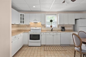 Enjoy cooking in this well-equipped kitchen with a stove, oven, and sink, plus a dining area for meals.