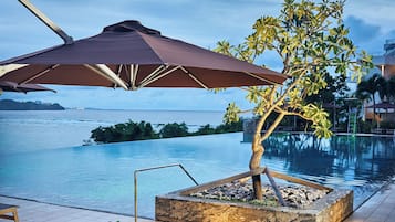 Een buitenzwembad, parasols voor strand/zwembad
