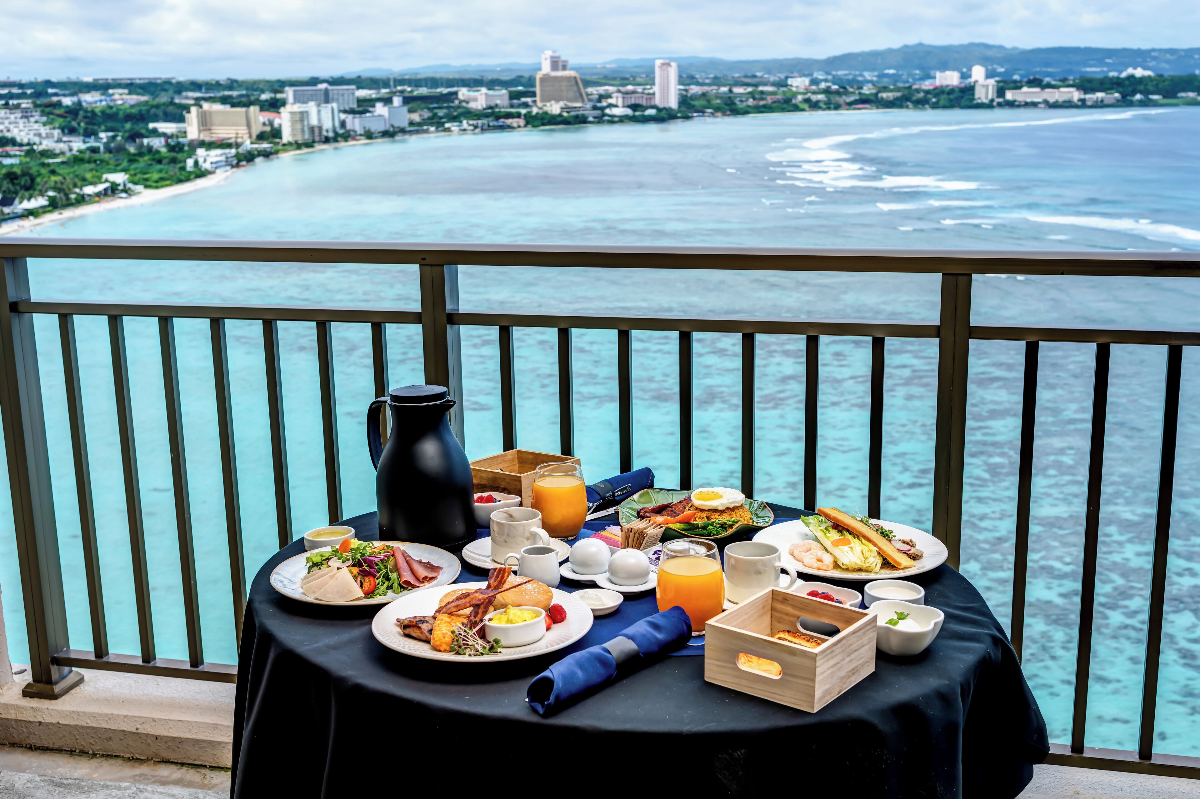 A table with breakfast items and a view of the ocean.