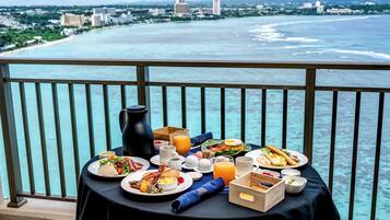 A table with breakfast items and a view of the ocean.