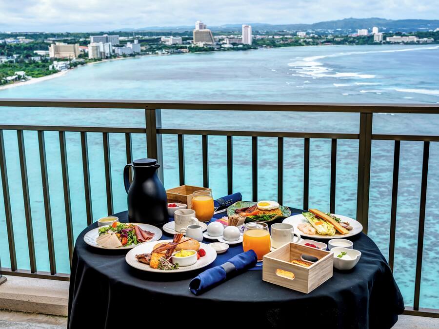 A table with breakfast items and a view of the ocean.