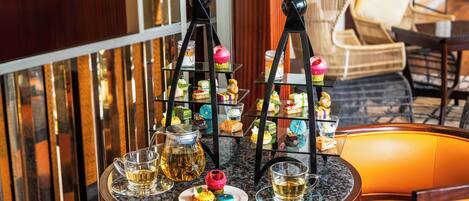Una presentación de postres con una mesa y sillas de cristal.