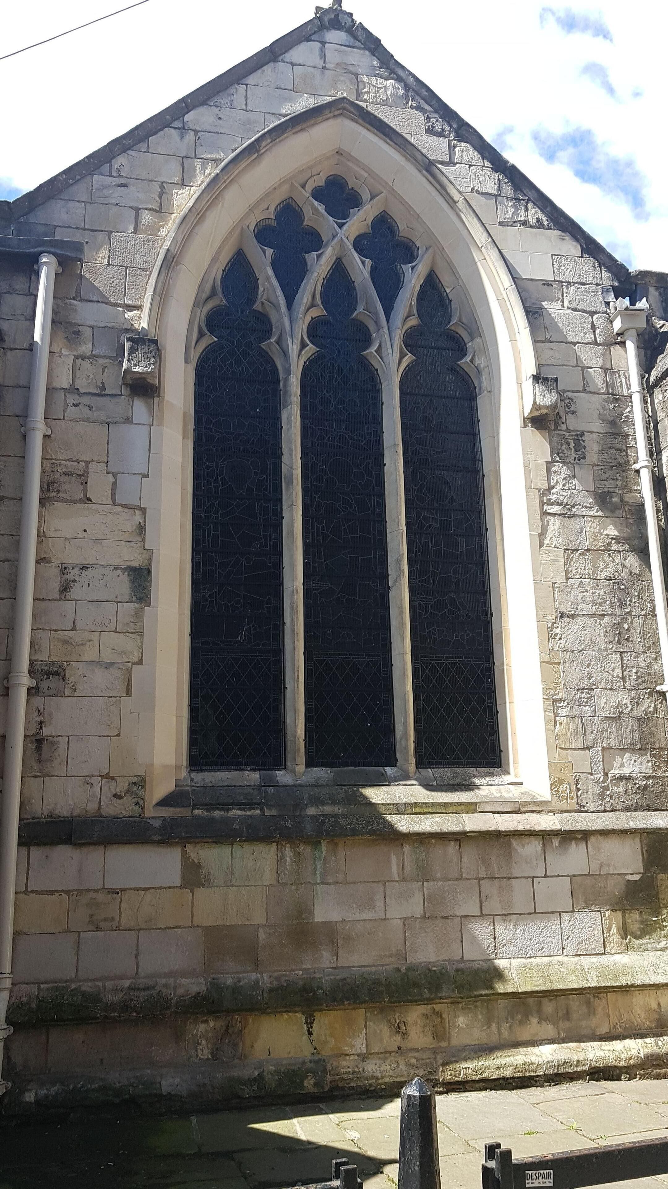A church with a pointed arch window and stone walls.