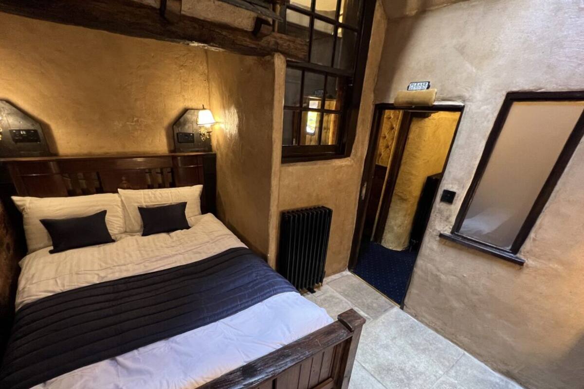 A bedroom with a wooden bed, a radiator, and a mirror on the wall.