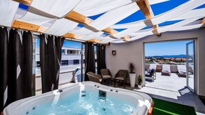A rooftop terrace with a hot tub, wicker chairs, and a view of the landscape. - Penthouse Luxury Suite (Zadar)