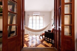 Quarto com rede, cadeira e piso estampado.