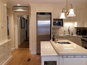 A modern kitchen with a stainless steel refrigerator, a microwave, a sink, and a stove. - Historic Brownstone Townhouse, 7 beds/3.5 baths, Fenway Boston (Boston)